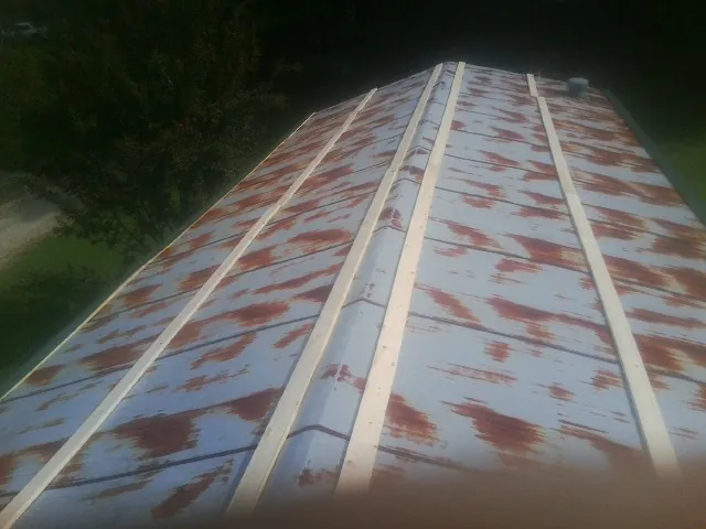 Rusted metal roof panels with new wood purlins before replacement — Storm Damage Roof Repair in West Sacramento by Roofing Brothers