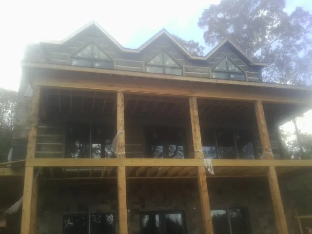 Dormers and porch framing on a large log home under construction — Roof Coating work by our crew in West Sacramento